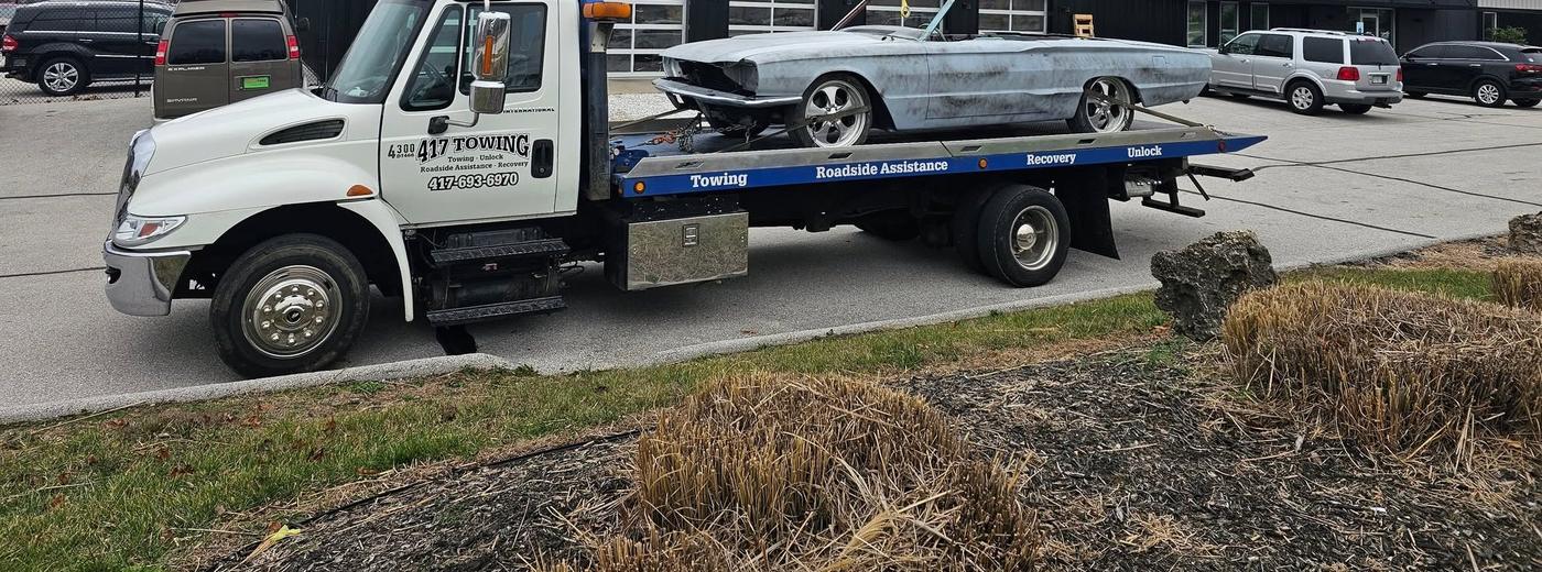 A classic convertible, unpainted and mid restoration, on the 417 Towing flatbed